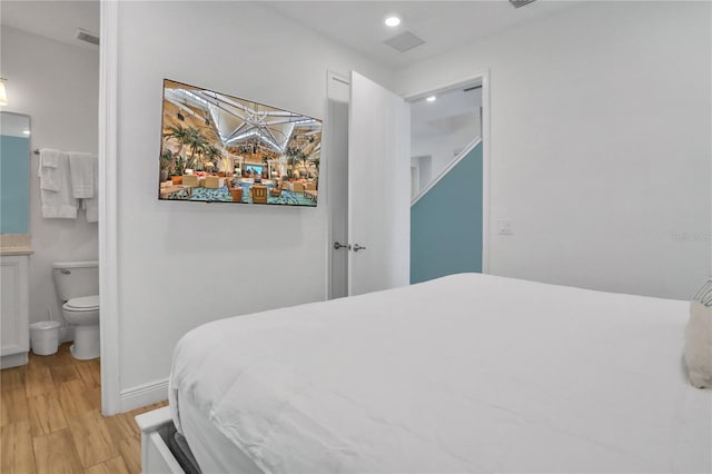 bedroom featuring light hardwood / wood-style floors and ensuite bath