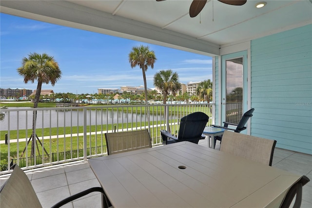 view of patio with a water view and ceiling fan