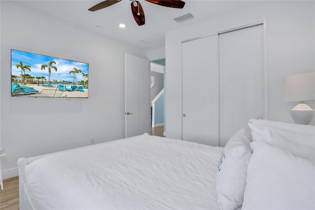 bedroom with ceiling fan, a closet, and light hardwood / wood-style flooring