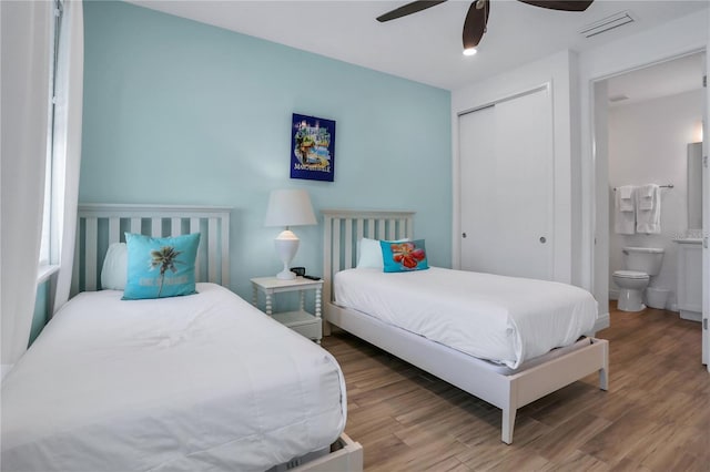 bedroom featuring ceiling fan, a closet, ensuite bathroom, and hardwood / wood-style floors