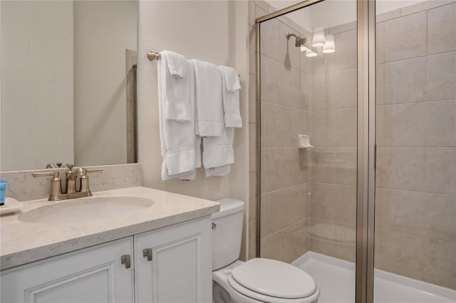 bathroom with toilet, vanity, and an enclosed shower