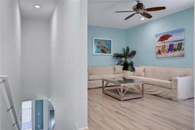 living room with light wood-type flooring and ceiling fan