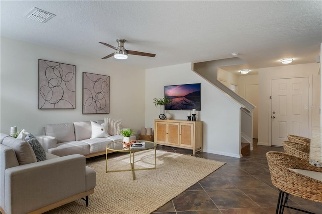 living room with ceiling fan and a textured ceiling