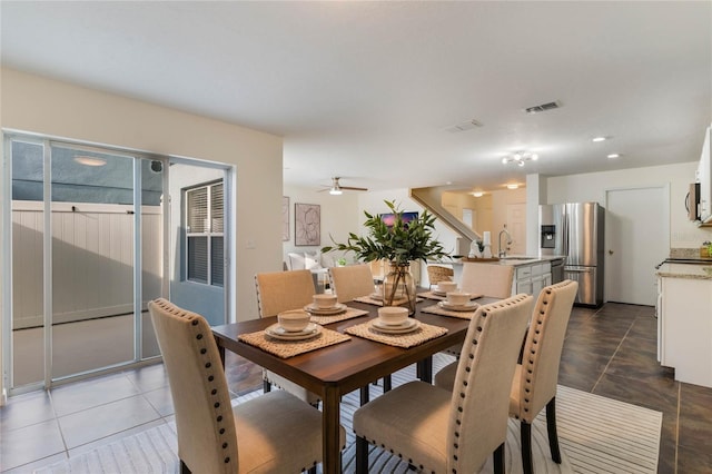 tiled dining area featuring sink and ceiling fan