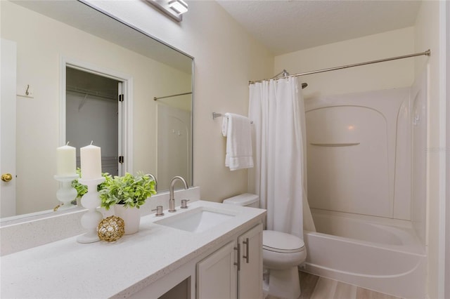 full bathroom with shower / tub combo with curtain, hardwood / wood-style flooring, vanity, a textured ceiling, and toilet