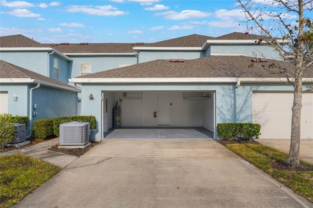 view of front of home with a garage, central AC, and water heater