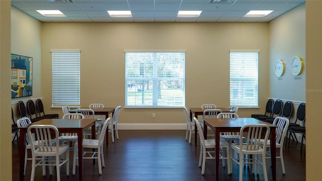 dining space with a paneled ceiling and dark hardwood / wood-style floors