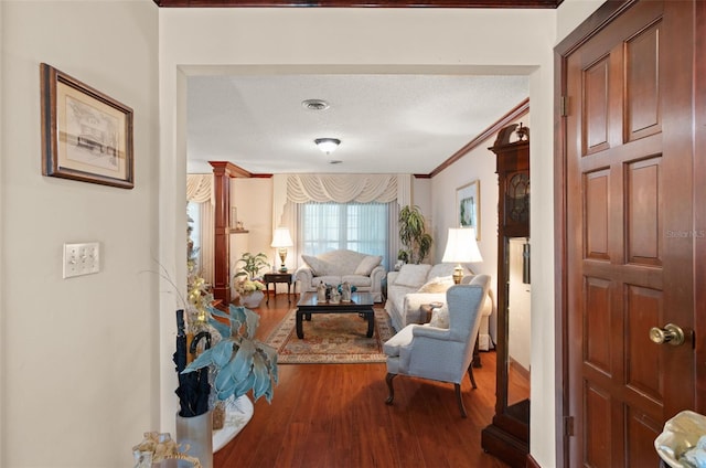 interior space featuring hardwood / wood-style floors, a textured ceiling, and ornamental molding