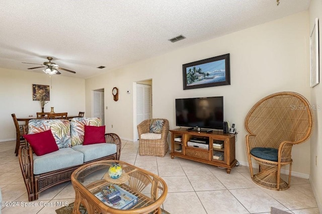 tiled living room featuring ceiling fan and a textured ceiling