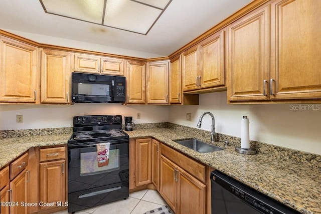 kitchen with light stone counters, sink, light tile patterned floors, and black appliances