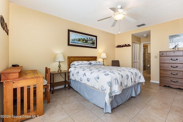 tiled bedroom with a textured ceiling, a closet, and ceiling fan