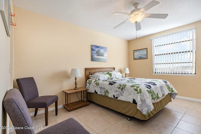 tiled bedroom with a textured ceiling and ceiling fan