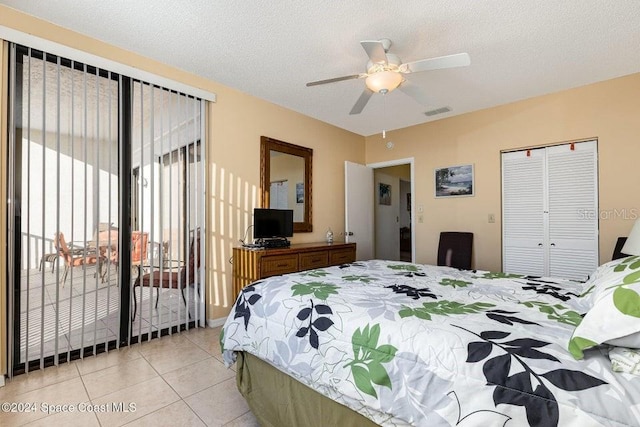 tiled bedroom with ceiling fan, a textured ceiling, access to outside, and a closet