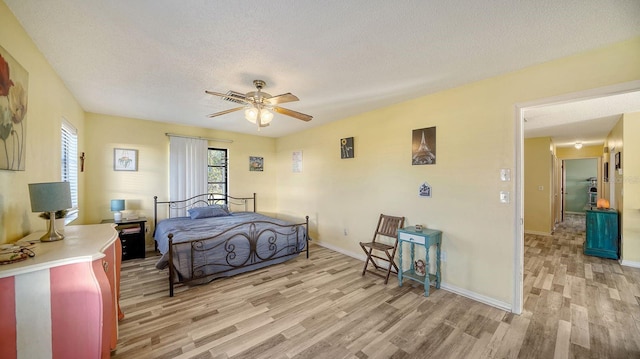 bedroom featuring ceiling fan, a textured ceiling, and light hardwood / wood-style flooring