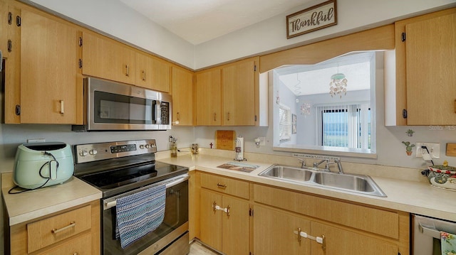 kitchen featuring sink, light brown cabinets, appliances with stainless steel finishes, and an inviting chandelier