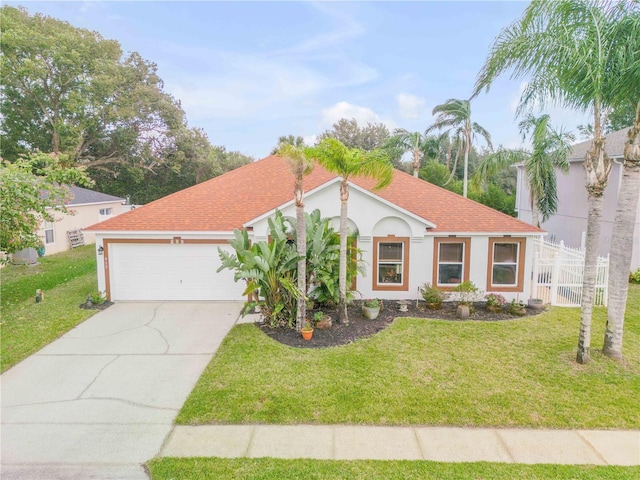 mediterranean / spanish home featuring a garage and a front yard