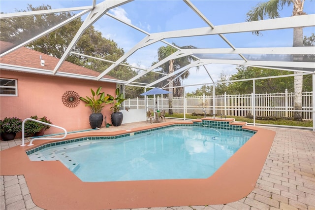 view of swimming pool with a patio area and a lanai