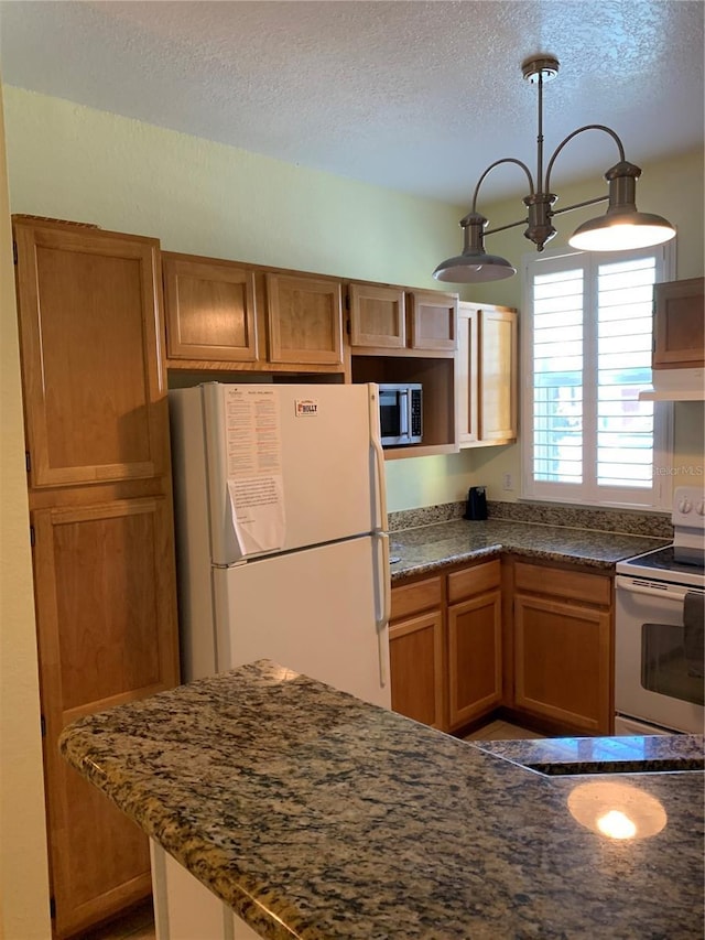 kitchen featuring an inviting chandelier, extractor fan, a textured ceiling, decorative light fixtures, and white appliances