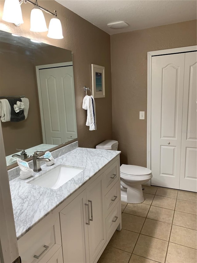 bathroom featuring tile patterned flooring, vanity, and toilet