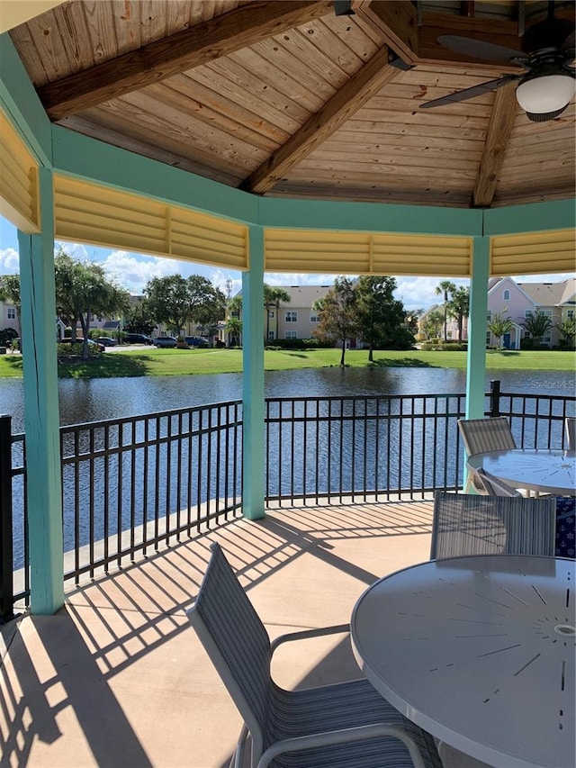 view of patio with a gazebo, ceiling fan, and a water view