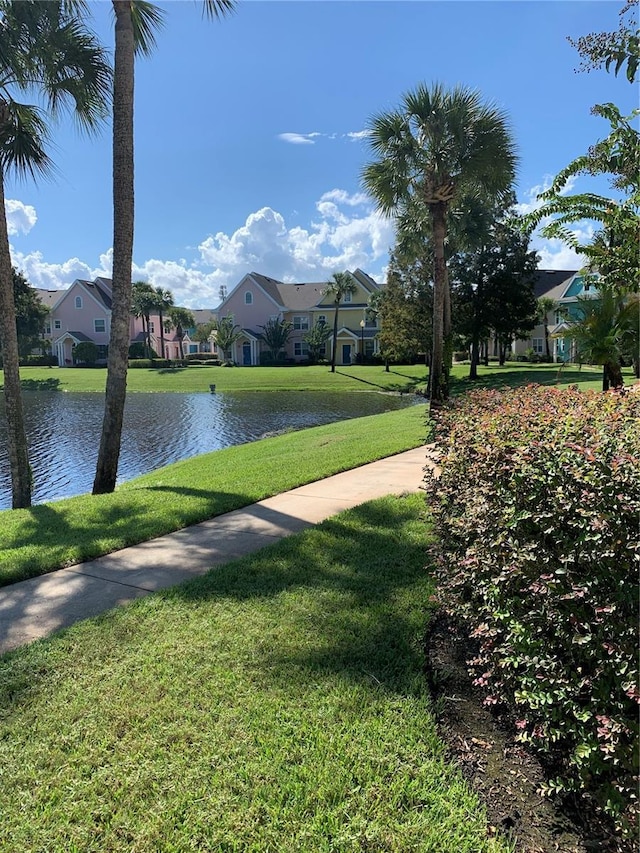 surrounding community with a lawn and a water view