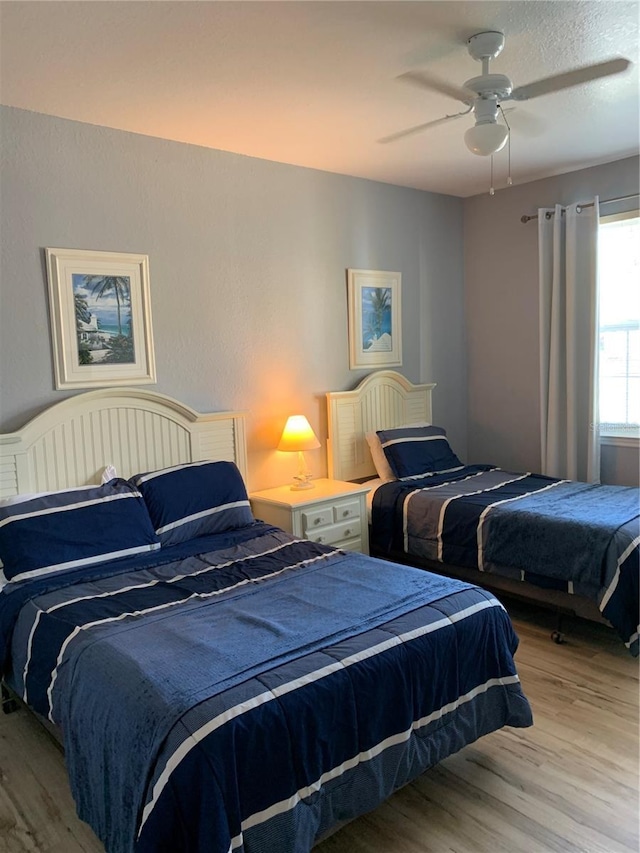 bedroom with hardwood / wood-style floors and ceiling fan