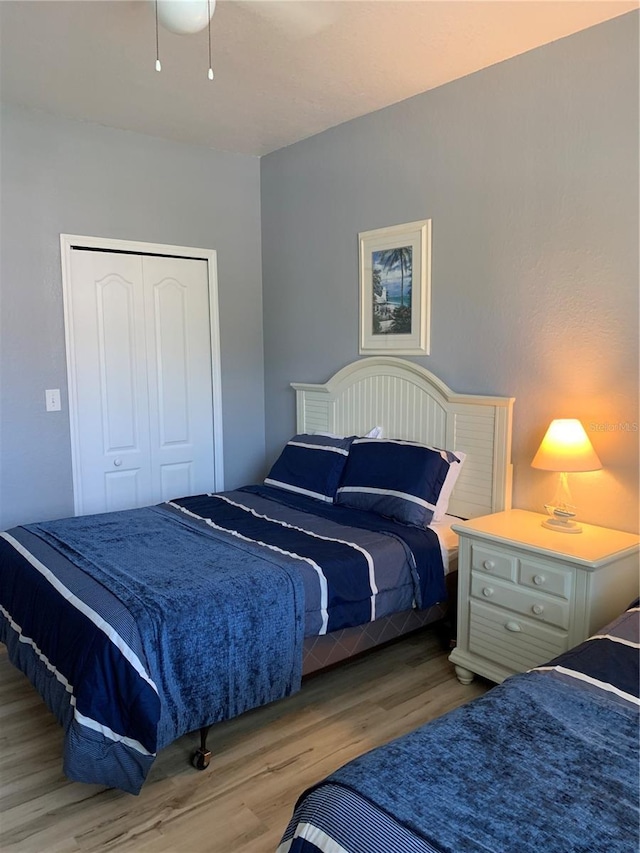 bedroom with light hardwood / wood-style flooring and a closet