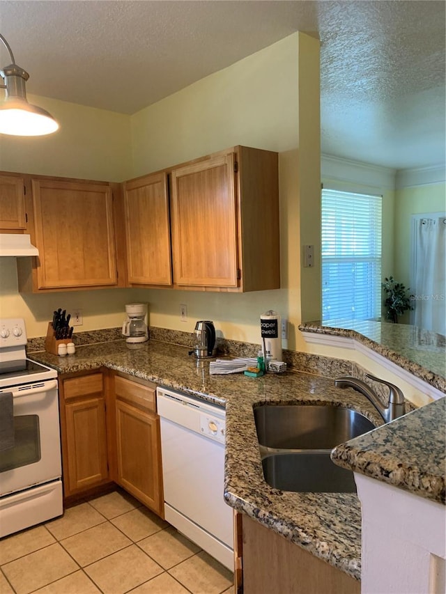 kitchen with white appliances, light tile patterned floors, a textured ceiling, under cabinet range hood, and a sink