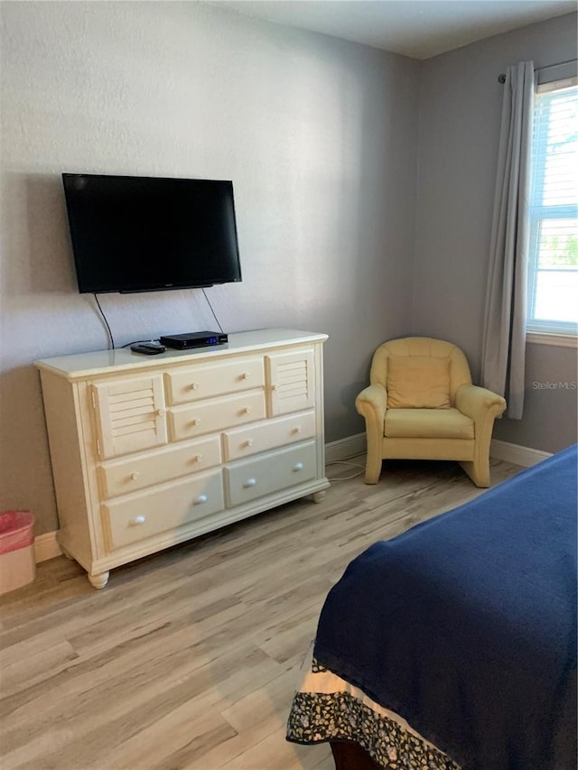 bedroom with light wood-style floors and baseboards