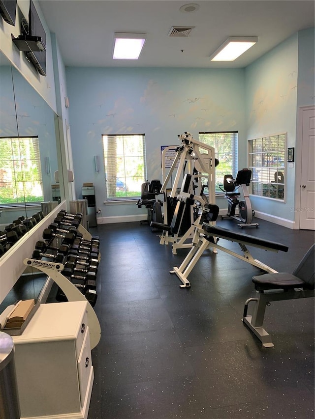 workout area with visible vents, plenty of natural light, and baseboards