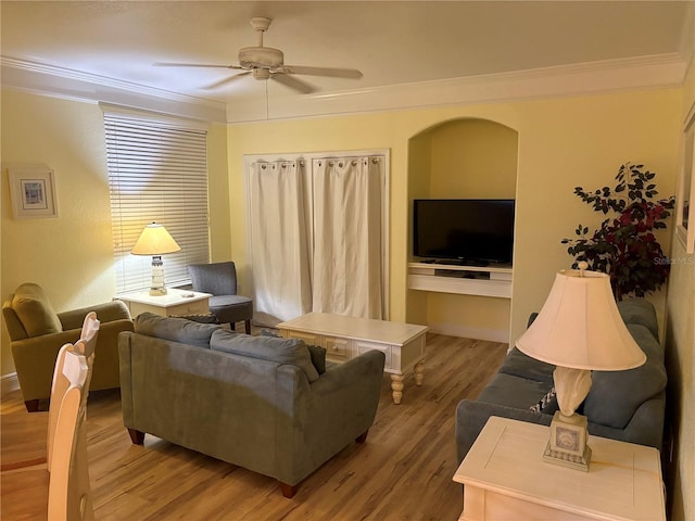 living room featuring ceiling fan, ornamental molding, wood finished floors, and baseboards