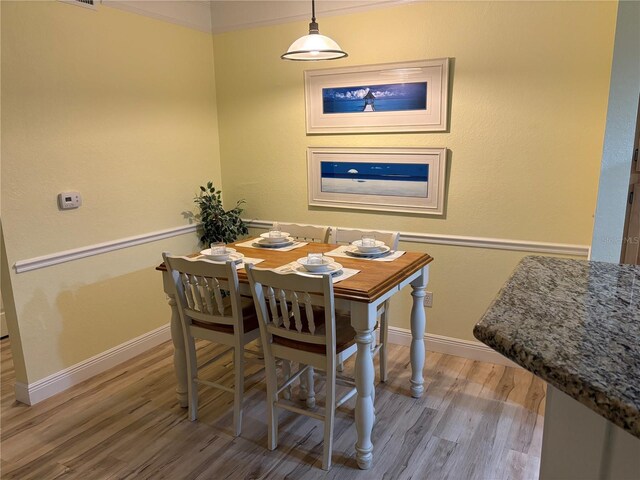 dining space with baseboards and wood finished floors