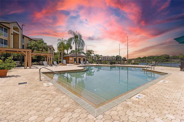 pool at dusk with a patio area