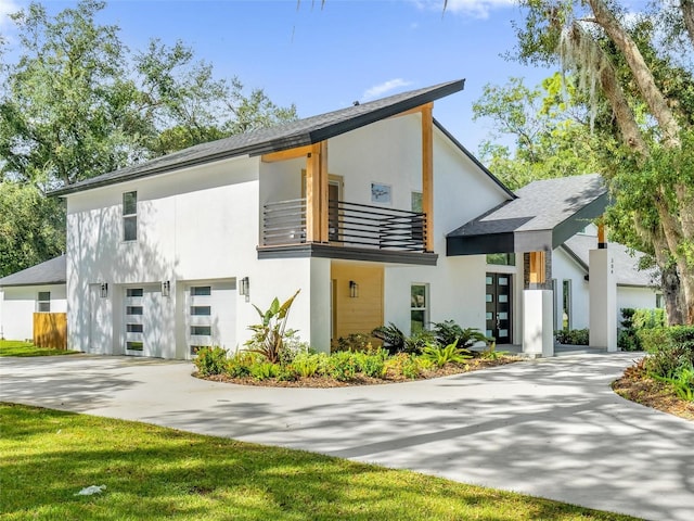 view of front of property featuring a balcony and a garage