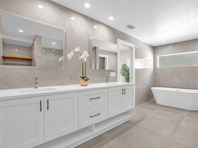 bathroom featuring a bathing tub, vanity, and tile walls