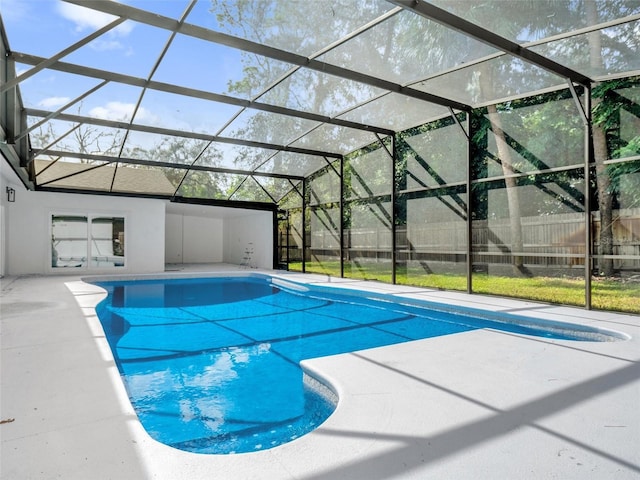 view of swimming pool featuring glass enclosure and a patio area