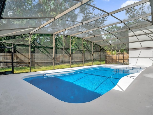 view of swimming pool with a patio area and a lanai