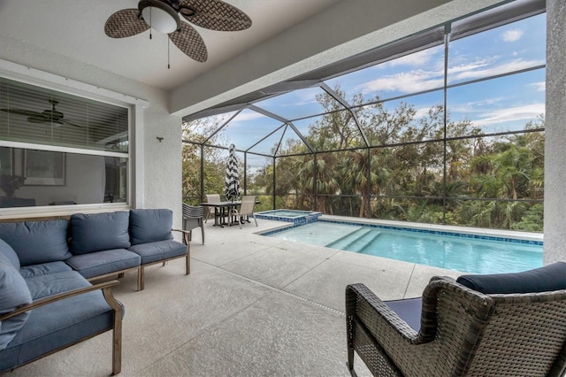 view of pool featuring a pool with connected hot tub, outdoor lounge area, a ceiling fan, a patio area, and a lanai