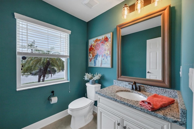 bathroom featuring baseboards, visible vents, vanity, and toilet