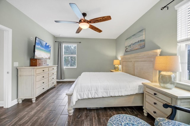 bedroom featuring dark wood-style flooring, a ceiling fan, and baseboards