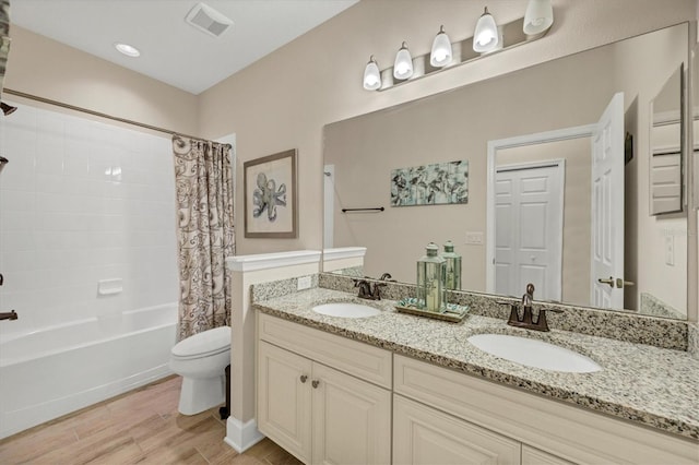 bathroom with toilet, shower / tub combo, a sink, and visible vents