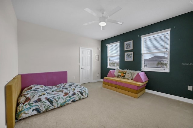 carpeted bedroom with a ceiling fan and baseboards