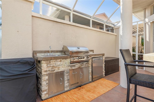 view of patio / terrace featuring area for grilling, a lanai, and sink