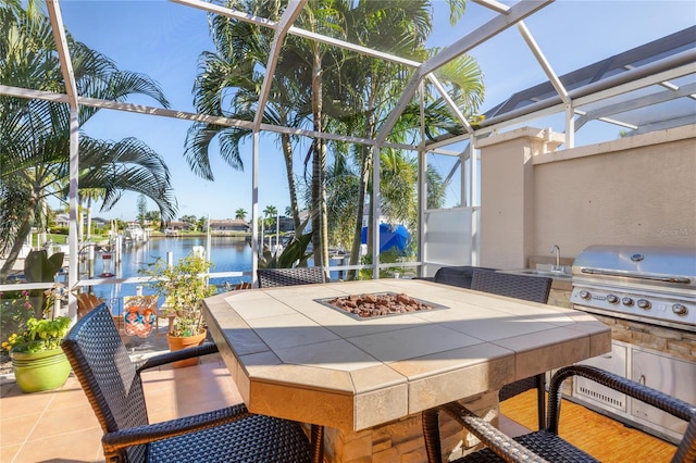 view of patio / terrace with grilling area, an outdoor kitchen, a water view, a lanai, and a wet bar