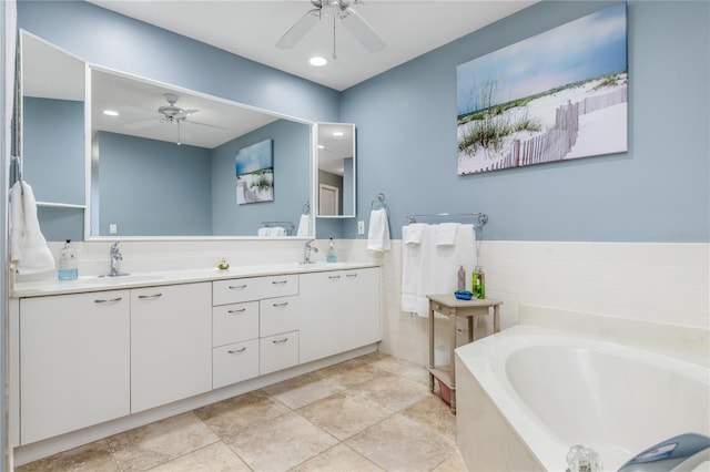 bathroom with a tub to relax in, ceiling fan, and vanity