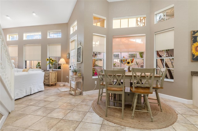 dining room featuring a high ceiling and light tile patterned floors