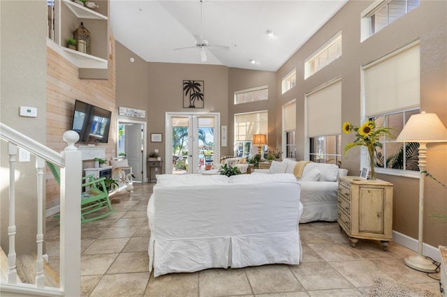 interior space with ceiling fan, access to exterior, a fireplace, and a high ceiling