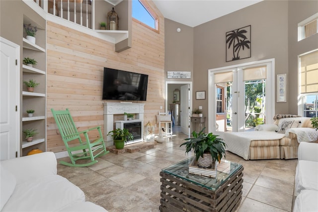 living room with plenty of natural light, french doors, a towering ceiling, and built in features