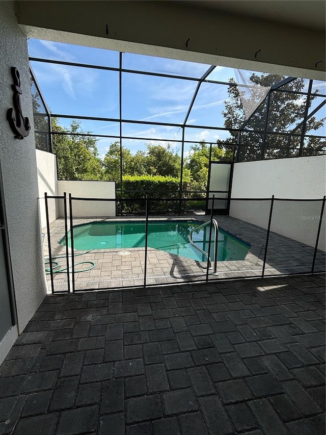 view of swimming pool featuring a lanai and a patio area