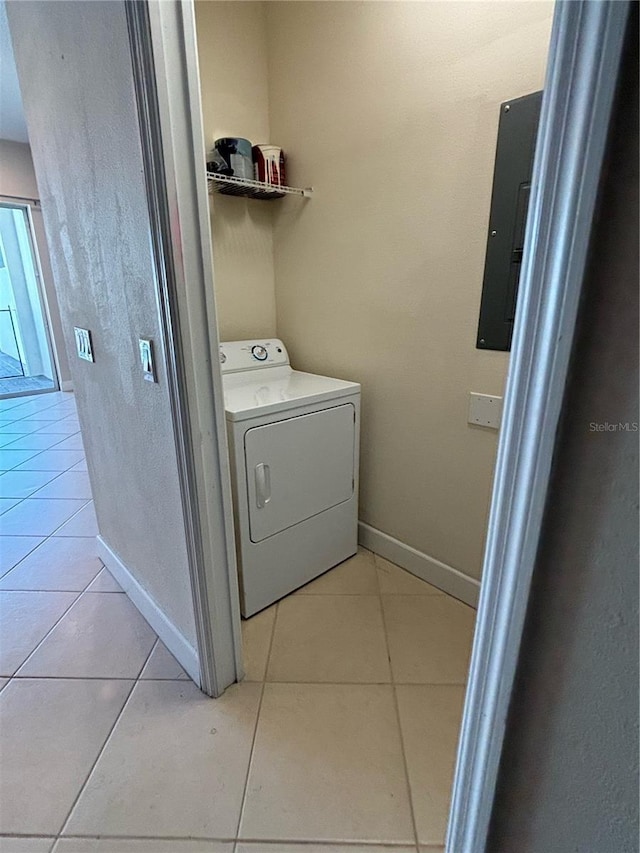 clothes washing area with light tile patterned flooring, electric panel, and washer / dryer